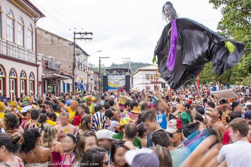 Imagem do trio elétrico e boneco no bloco de carnaval.